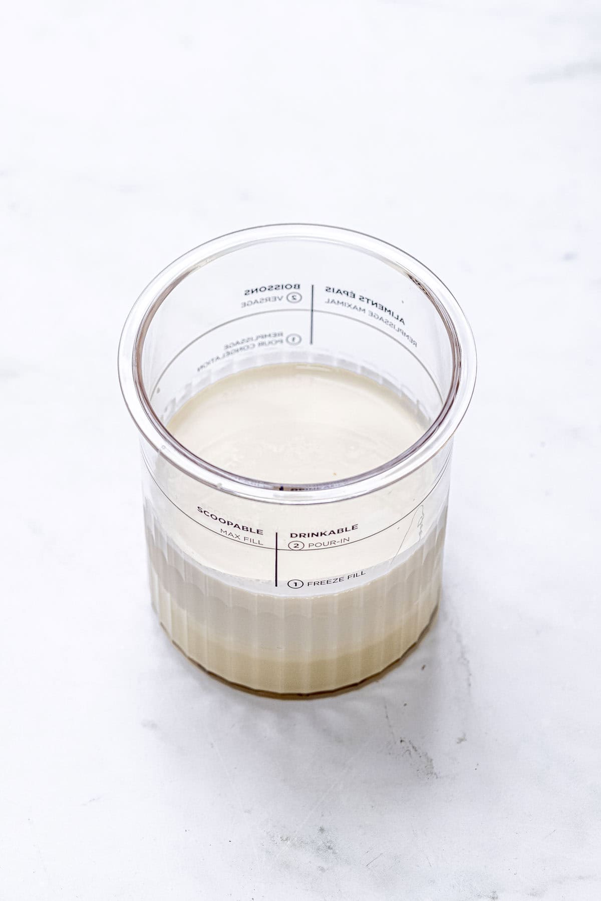 ingredients for vanilla ice cream in ninja creami tub.