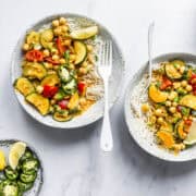 two bowls of courgette curry served over basmati rice.