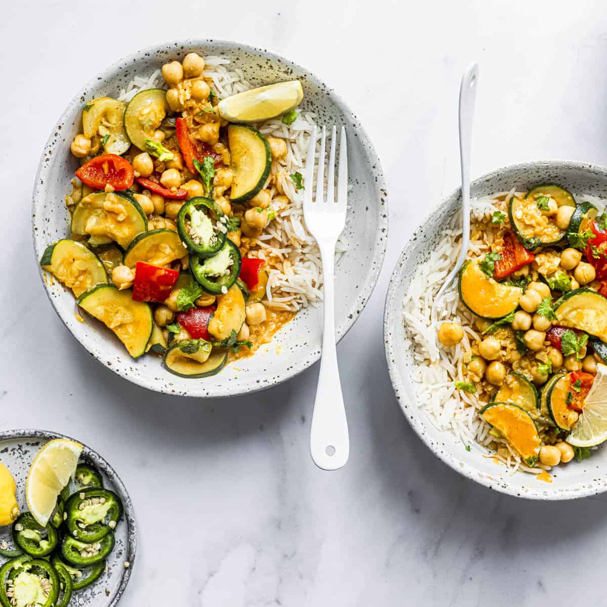 two bowls of courgette curry served over basmati rice.