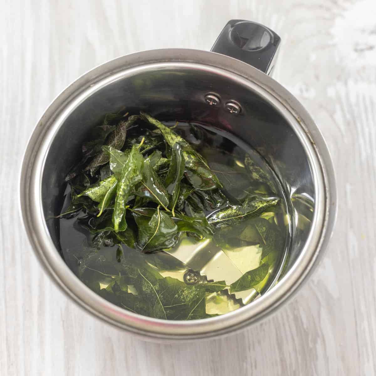 curry leaves and oil in a blender jar.