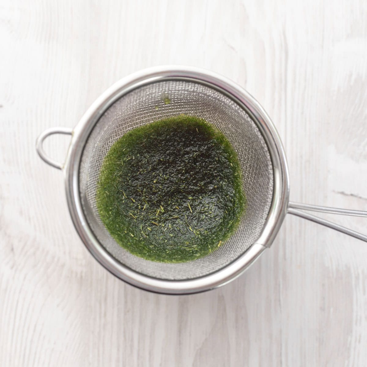 curry leaf oil residue in a tea strainer.