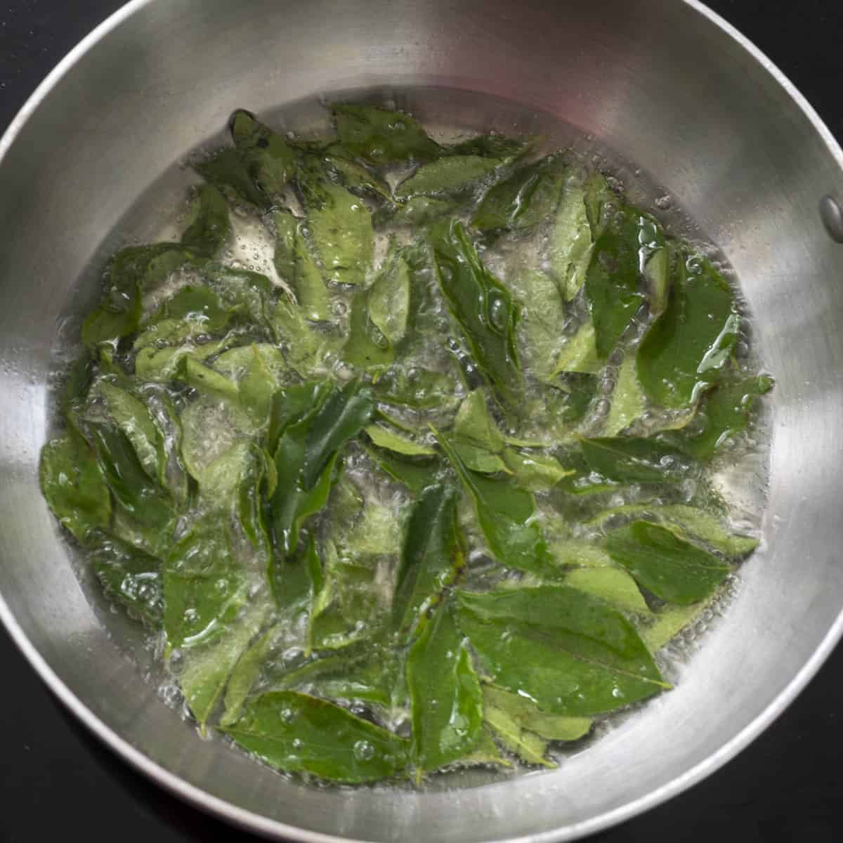 curry leaves sizzling in oil