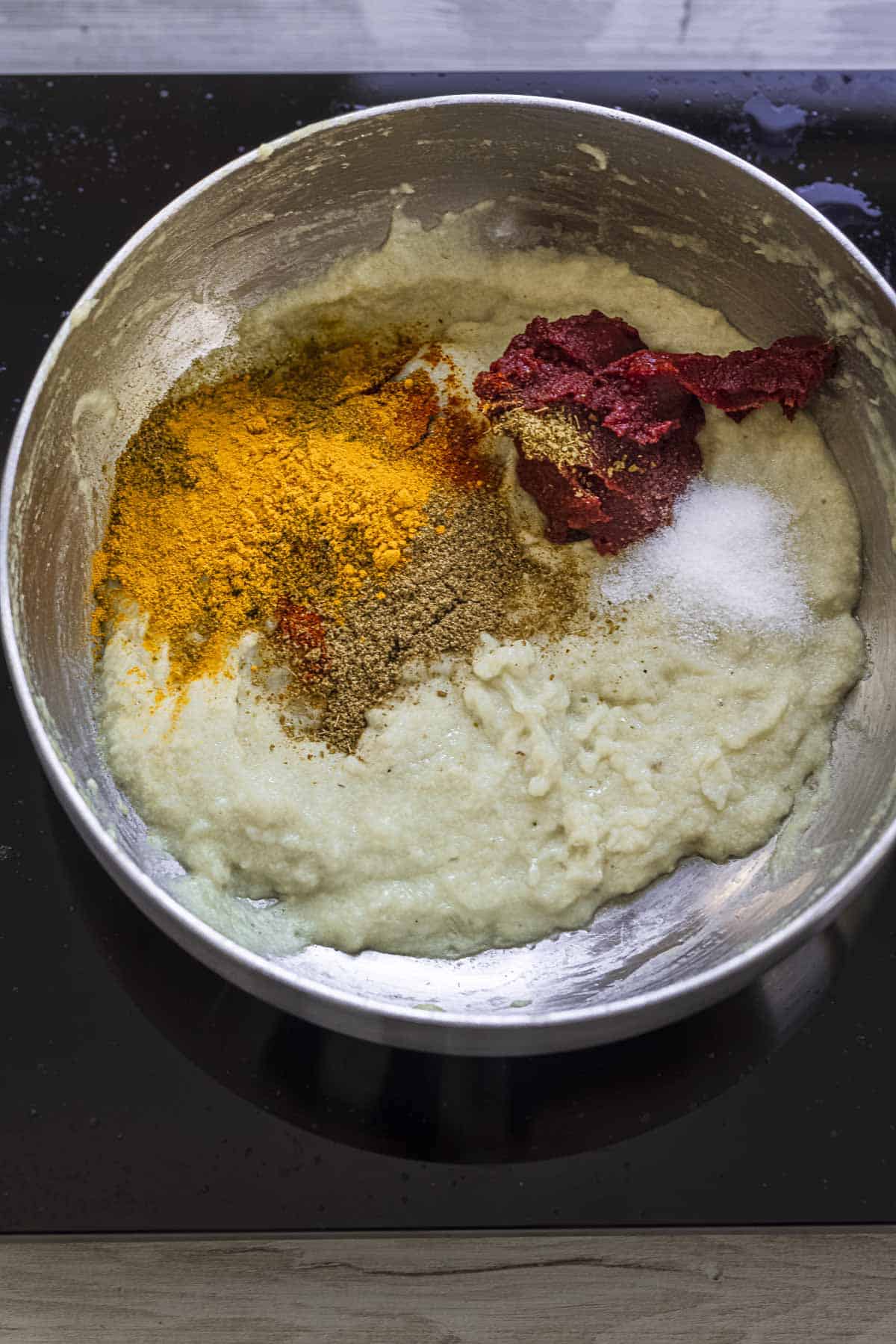 cooked onion paste with spices and tomato puree in a sauce pan.