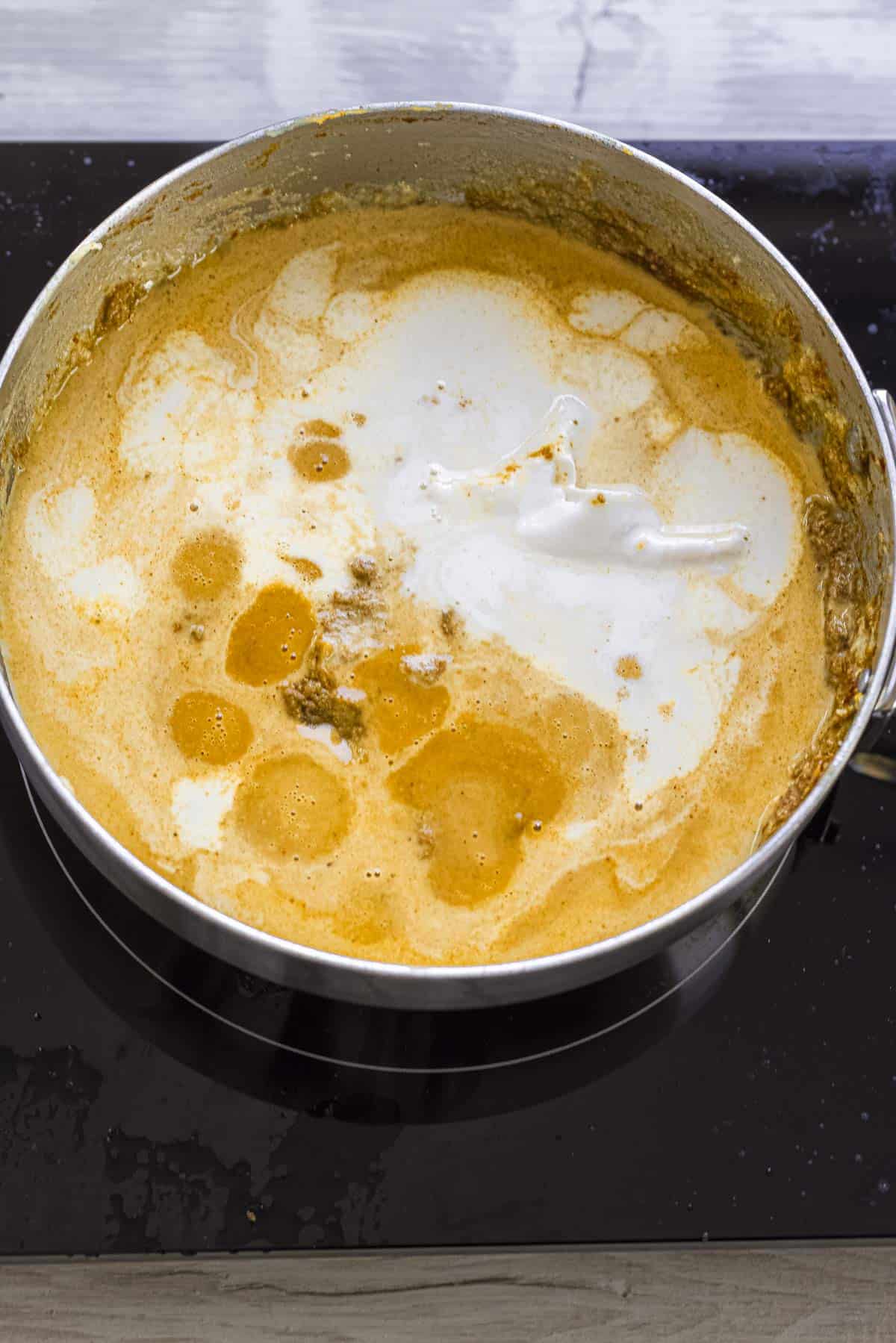 korma sauce cooking on induction hob.