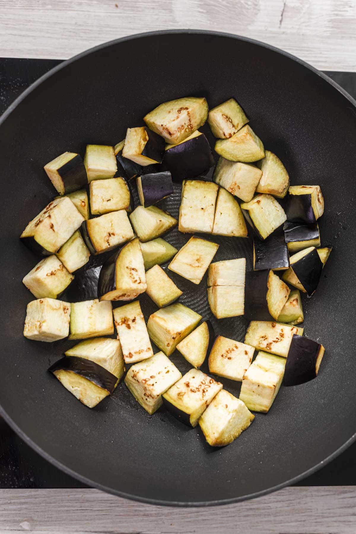 diced aubergine in a wok
