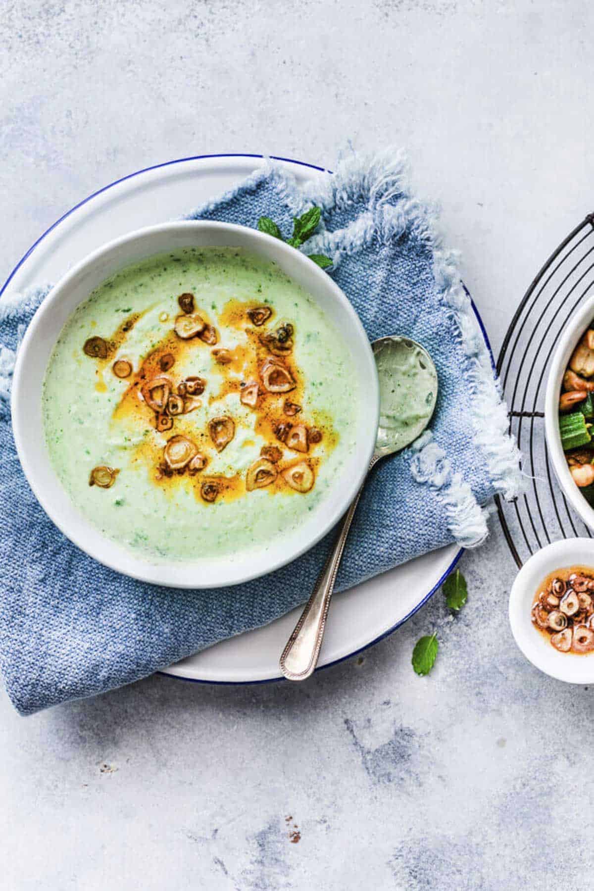lauki raita served in a white bowl with garlic tempering.