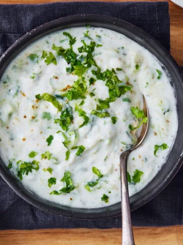 vegan cucumber raita served in a black bowl.