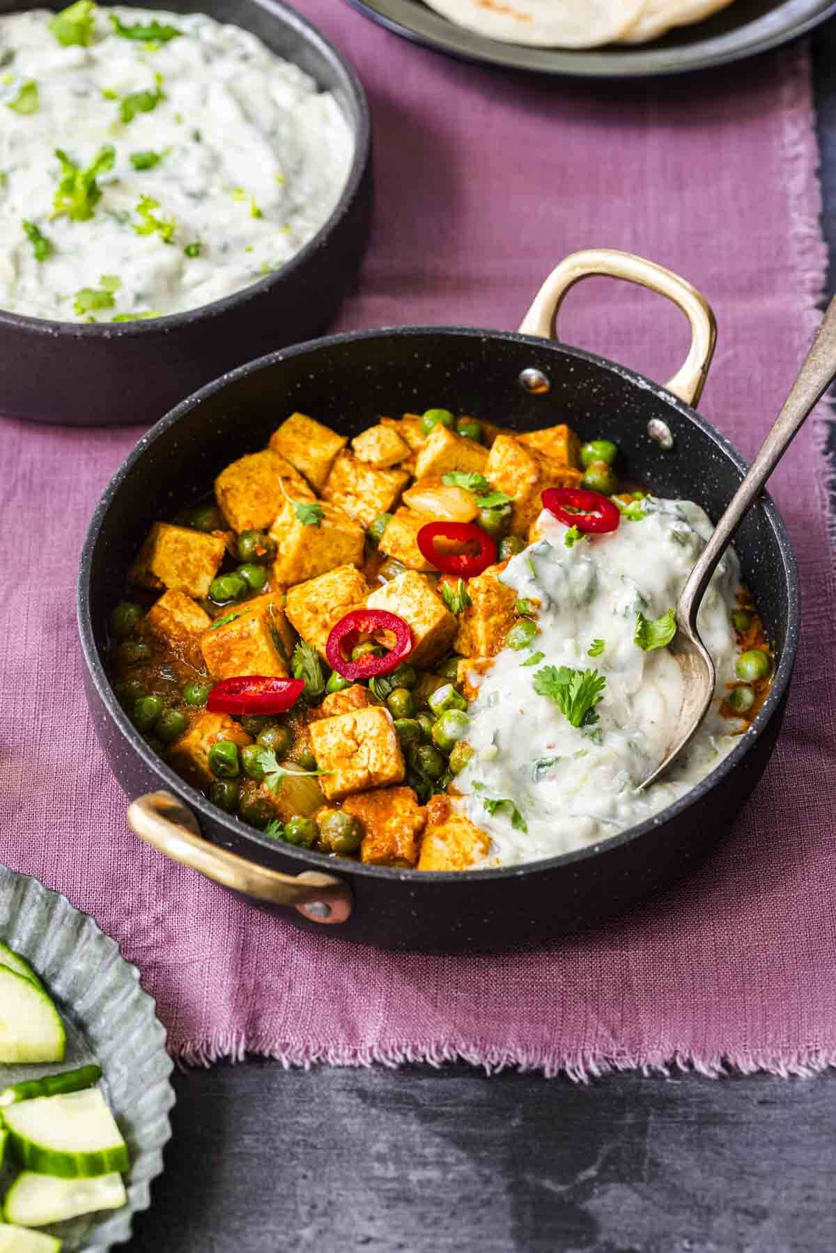 tofu korma served with vegan cucumber raita in a bowl.