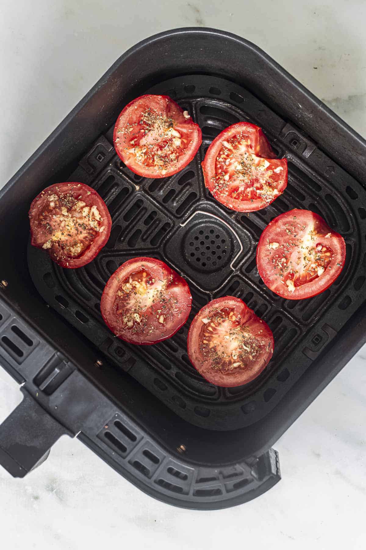 fresh tomatoes cut in half and seasoned for air fryer roasted tomatoes