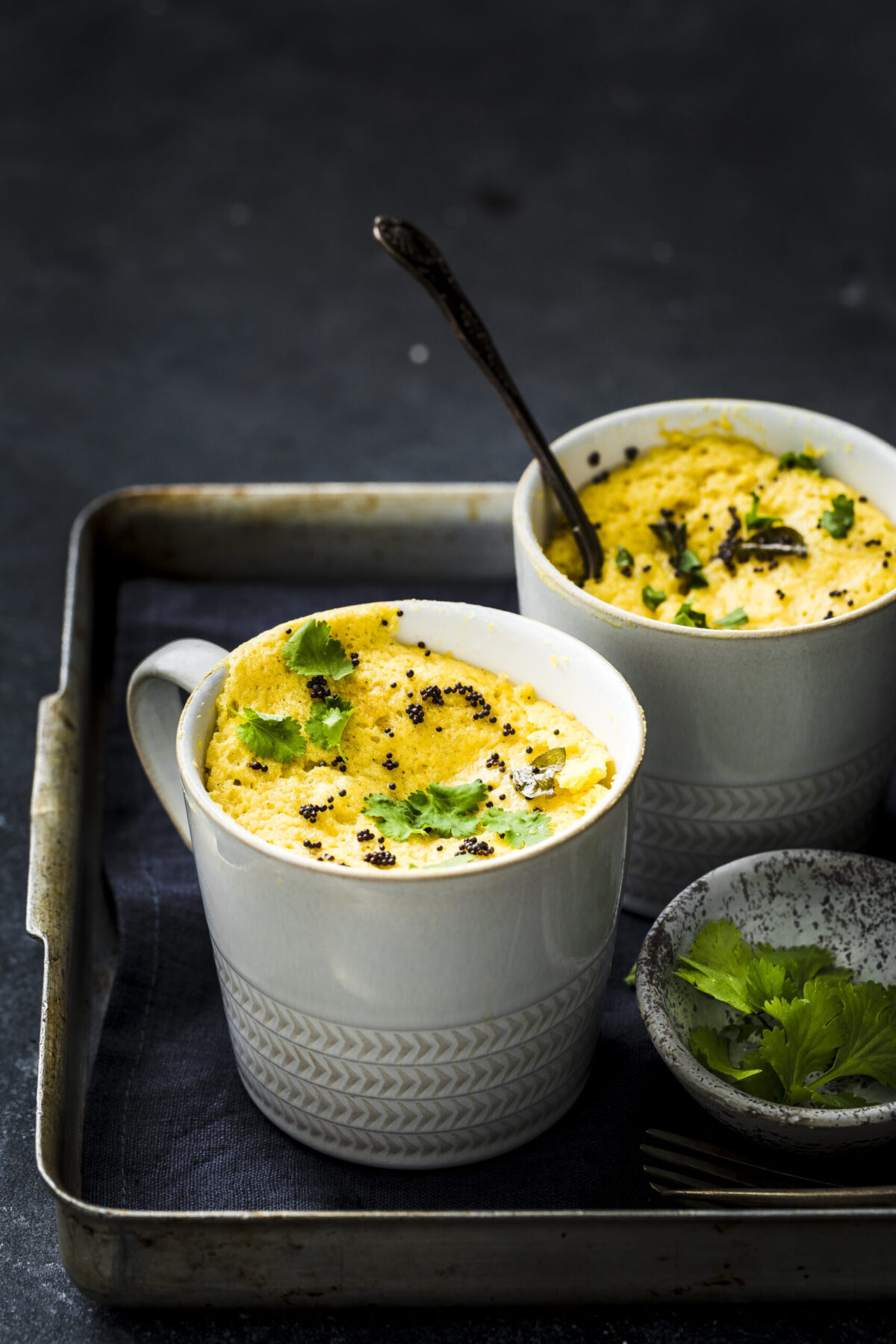 two white mugs of instant khaman dhokla.