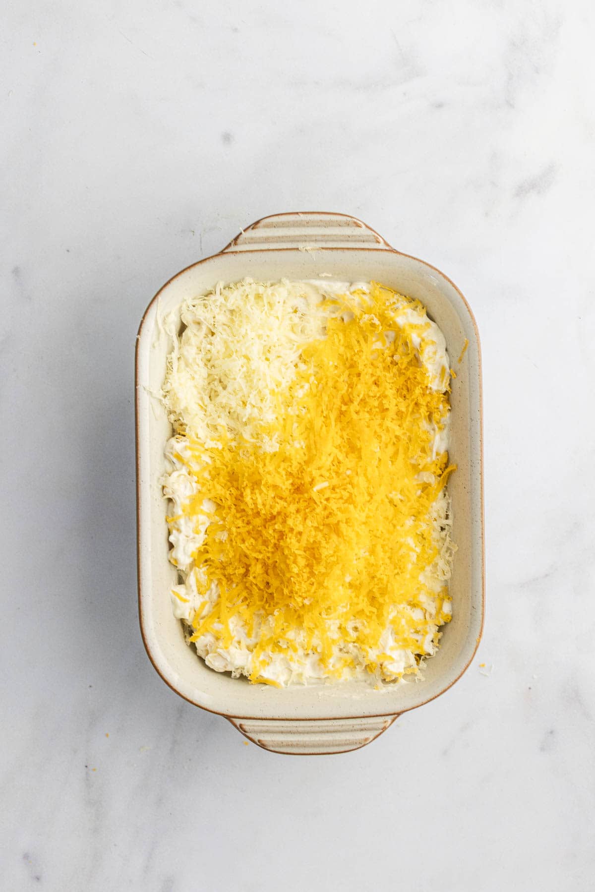 add grated cheese on the top of creamed corn in a baking dish.