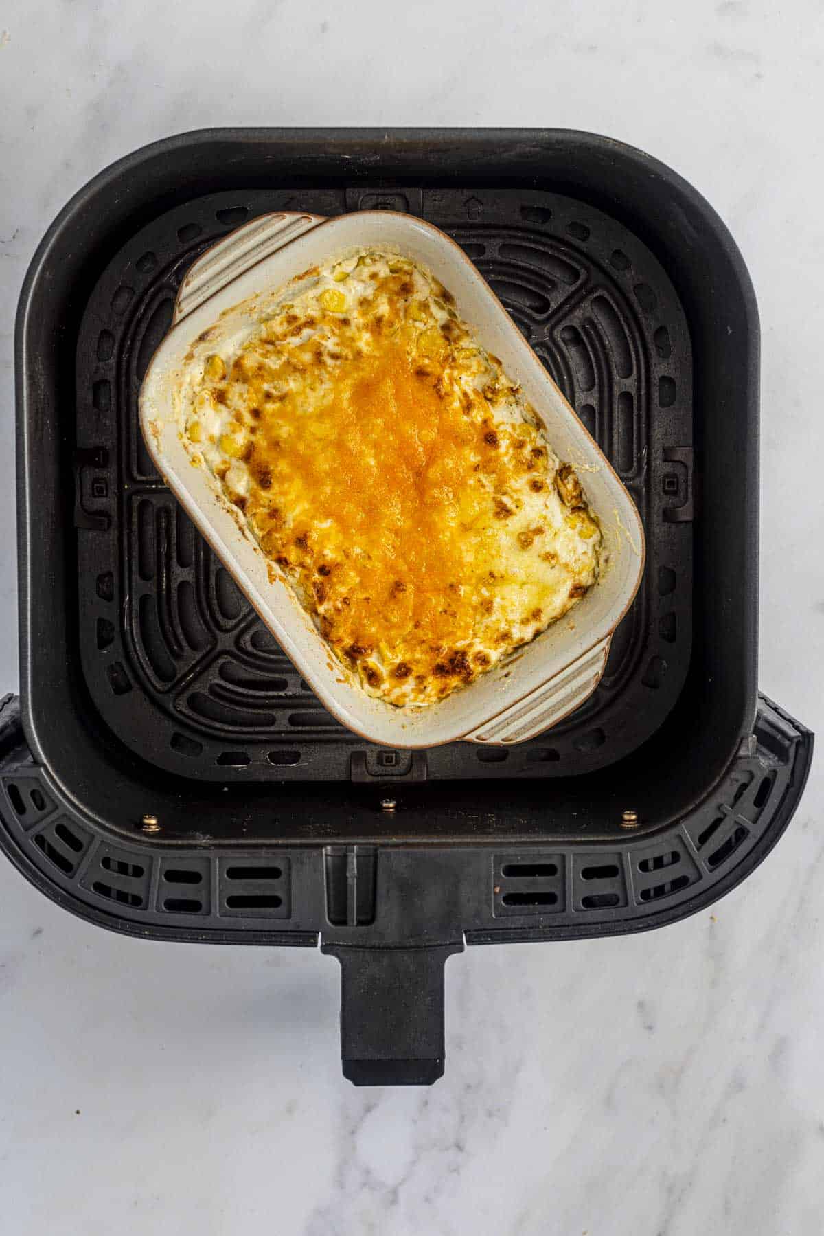 air fried creamed corn in air fryer basket.