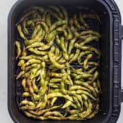 air fried edamame in pods in air fryer basket.