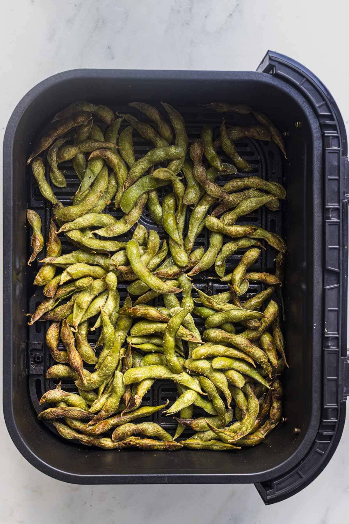 air fryer edamame in air fryer basket.