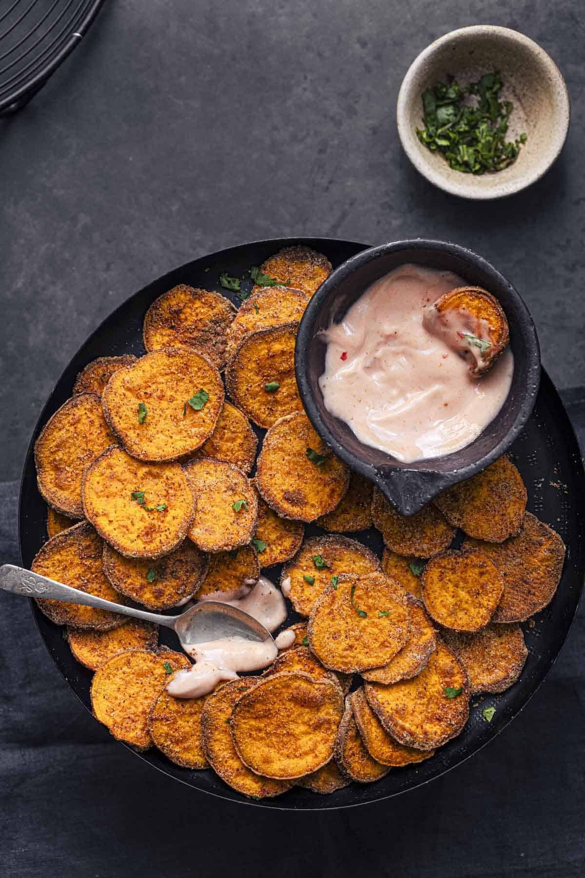 serve crispy sweet potato slices with sauce.