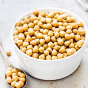 cooked chickpeas from dried beans in a white bowl.