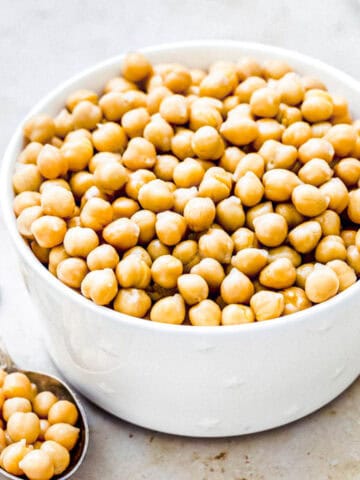 cooked chickpeas from dried beans in a white bowl.