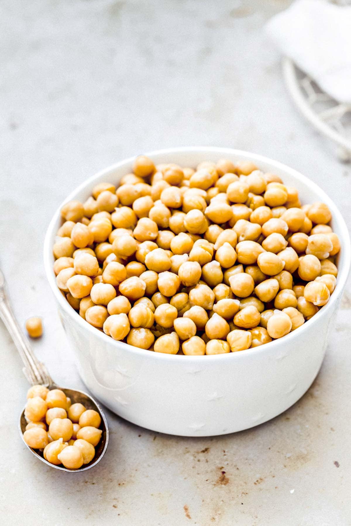 cooked chickpeas from dried beans in a white bowl.
