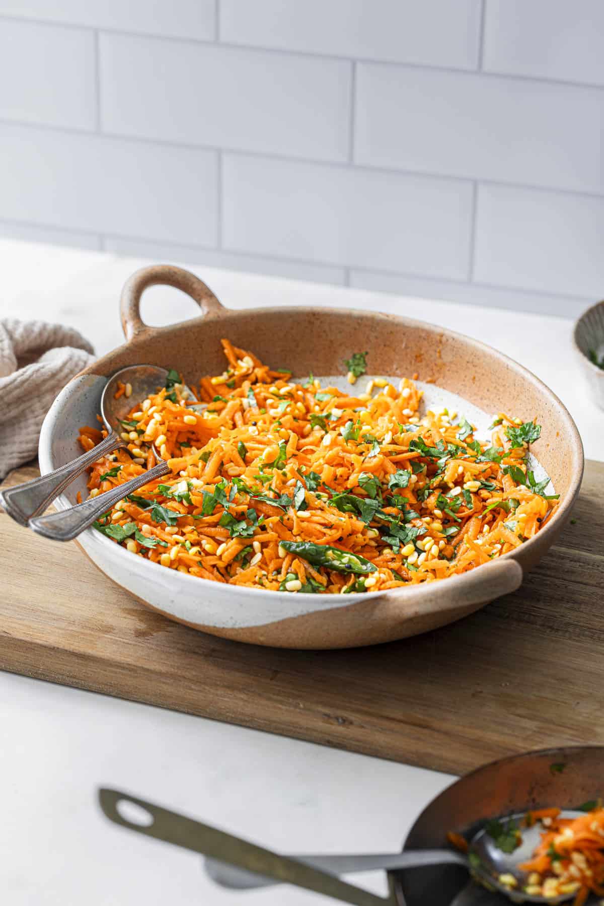 a bowl of Indian moong dal carrot kosambari salad in a bowl with two spoons.