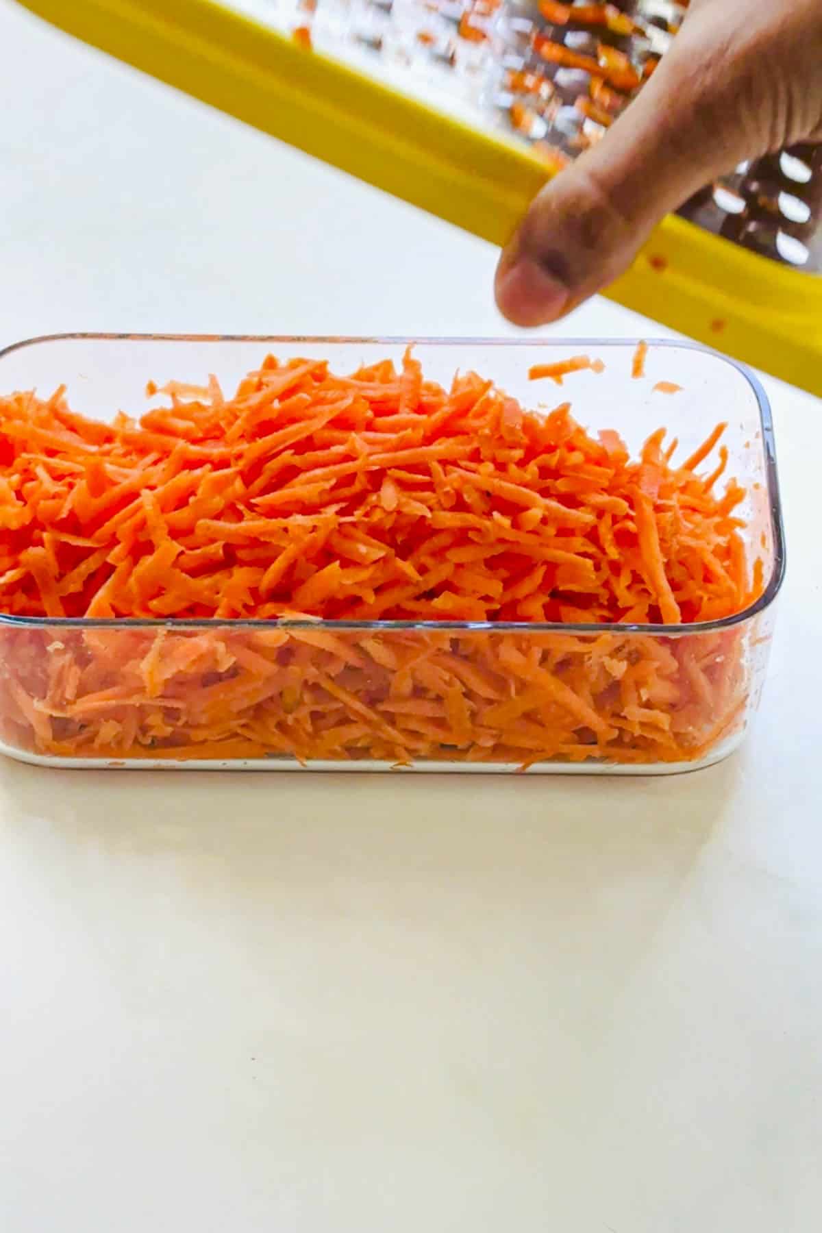 grated carrots in a rectangle plastic container.
