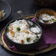 a bowl of vegan South Indian coconut rice topped with cashews and curry leaves.