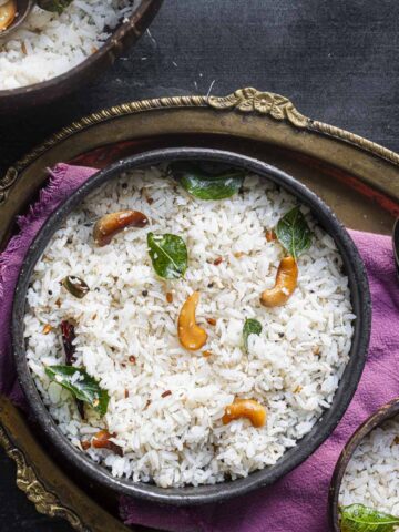 a black bowl of vegan South Indian coconut rice aka thengai sadam.