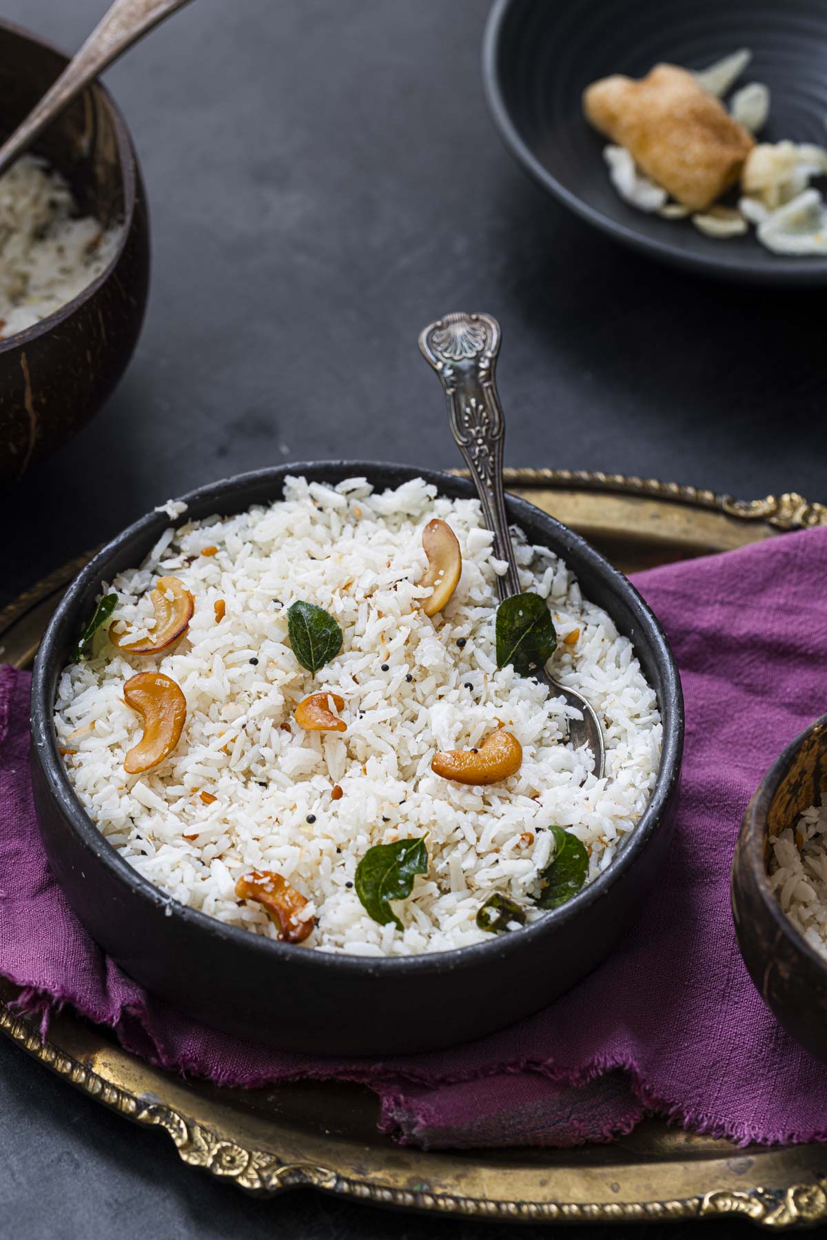 a bowl of vegan South Indian coconut rice topped with cashews and curry leaves.