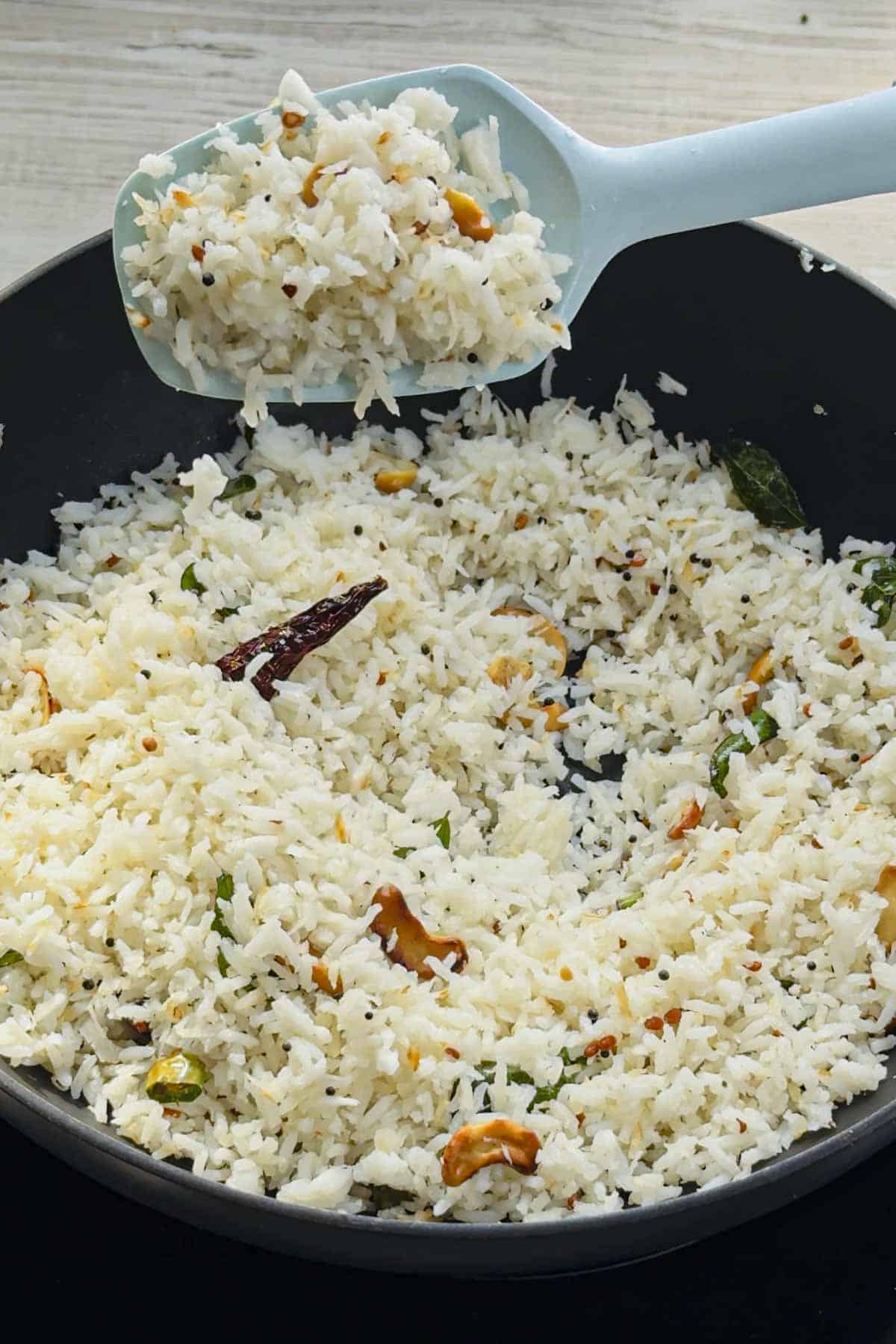 homemade thengai sadam (South Indian Coconut Rice) in a black wok.