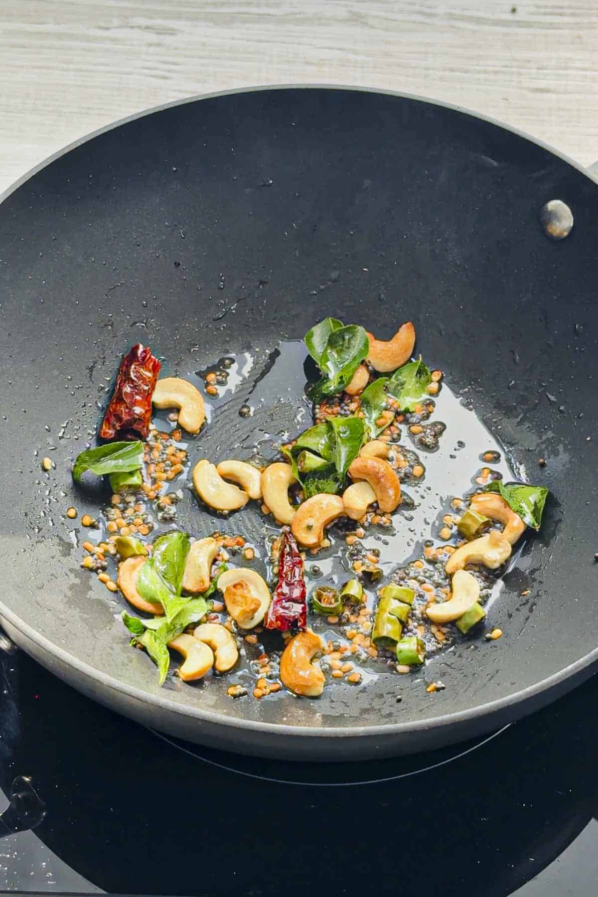 south indian tempering in a wok to make indian coconut rice.