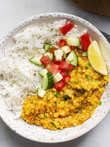 red lentil dal served with white basmati rice and kachumber salad.