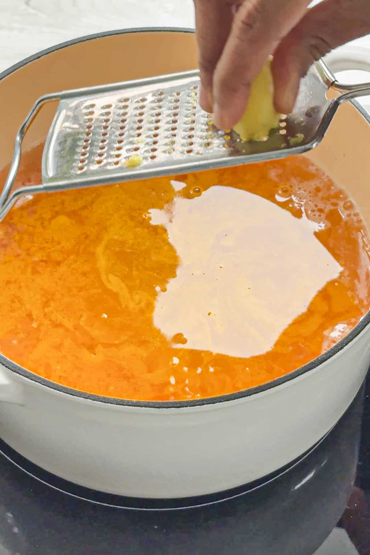 adding grated ginger to red lentils.