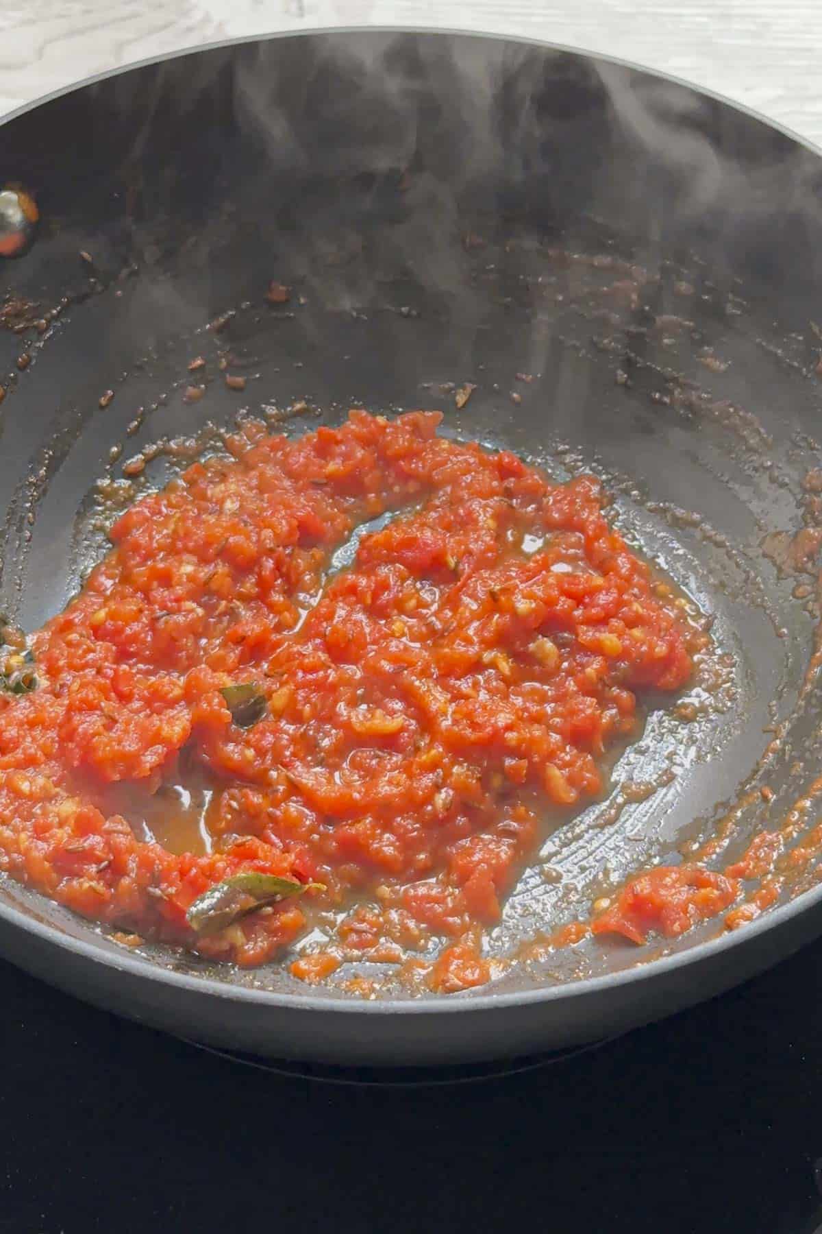 cooked tomato mixture for the dal in a wok.