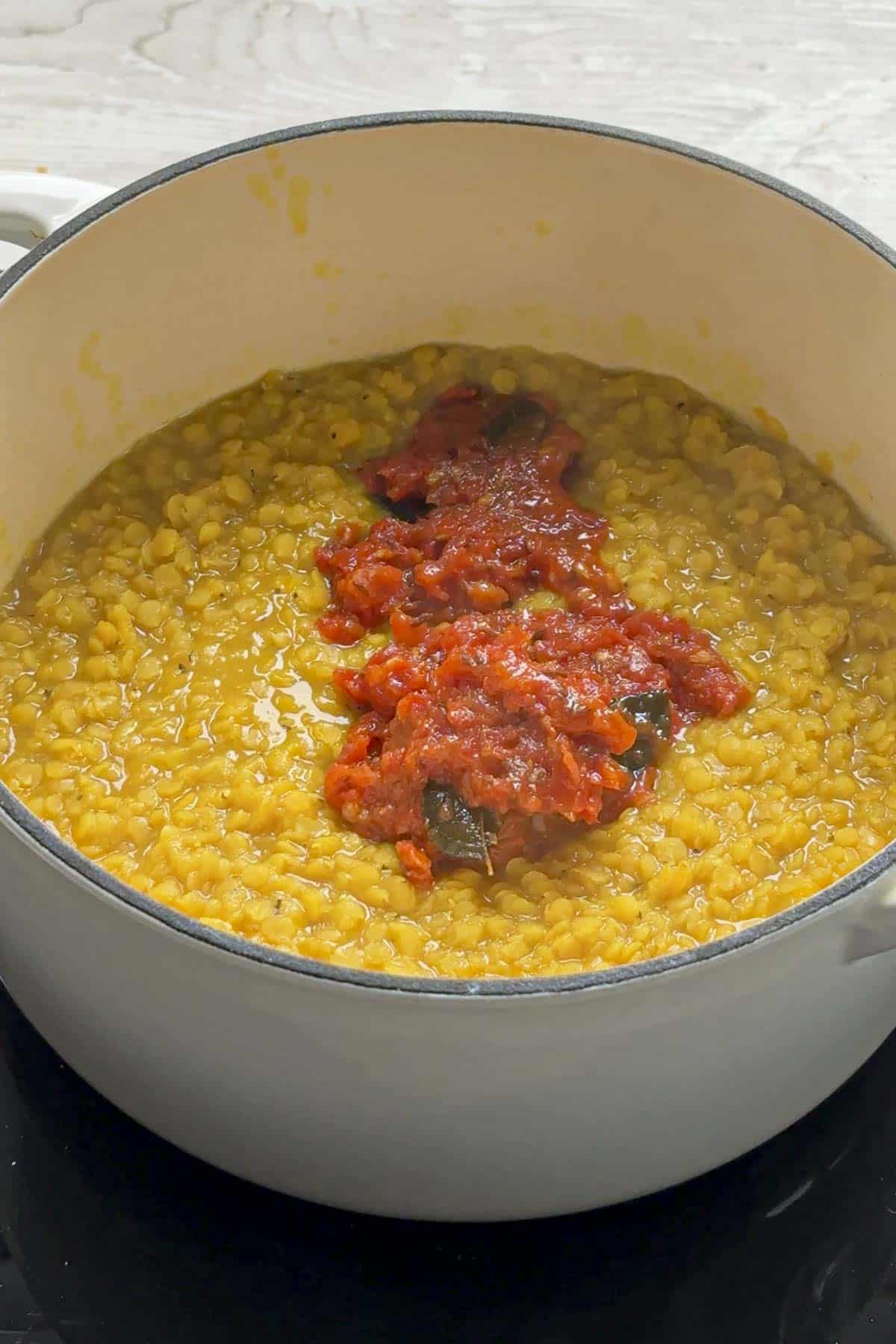 cooked red lentil dal with tomato mixture.