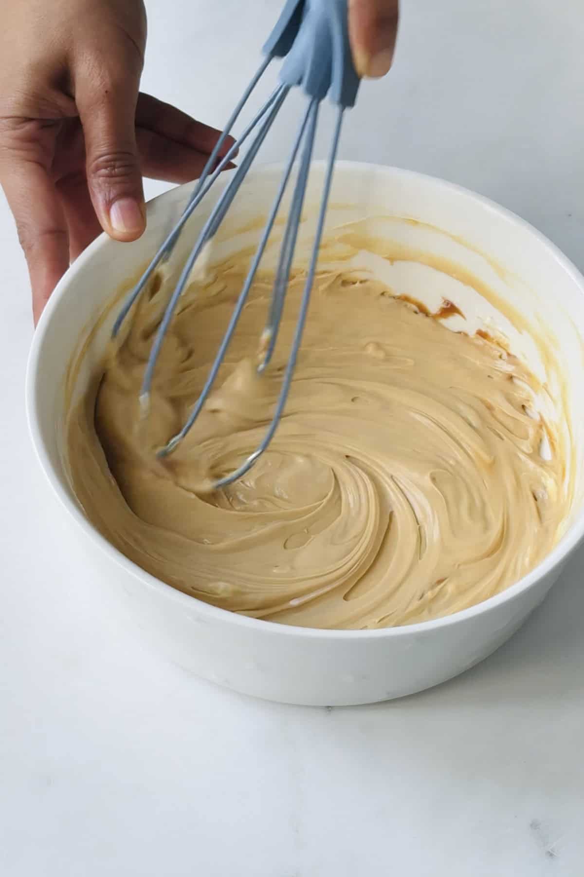 cream cheese and caramel whisked in a bowl.